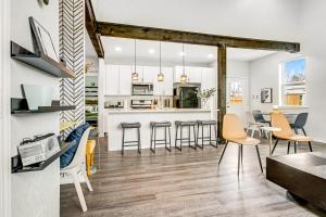 uma cozinha e sala de estar com paredes brancas e pisos de madeira em The Selfie House em San Antonio
