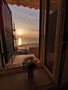 a window with a view of the ocean at sunset at Pensione La Torretta in Peschici