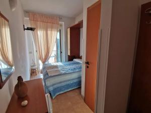 a bedroom with a bed and a door to a balcony at Pensione La Torretta in Peschici