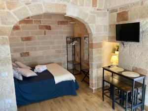 a bedroom with a bed in a stone wall at Tresor 65 in Polignano a Mare