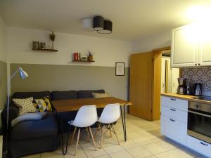 een keuken en een woonkamer met een tafel en stoelen bij Ferienwohnung Haus Weinbergsblick in Kirschroth