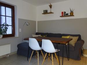 een woonkamer met een tafel en 2 witte stoelen bij Ferienwohnung Haus Weinbergsblick in Kirschroth