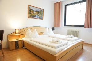 Hotel Kaffeemühle في فيينا: غرفة نوم بسرير وملاءات بيضاء ونافذة