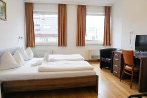 1 dormitorio con 2 camas y escritorio con ordenador en Hotel Kaffeemühle en Viena