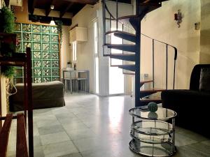 a living room with a staircase and a glass table at Sweet Triana in Seville