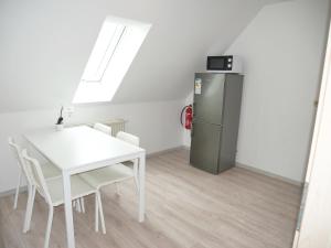 ein Esszimmer mit einem Tisch und einem Kühlschrank in der Unterkunft SUNNYHOME Monteurwohnungen und Apartments nahe Regensburg in Nittendorf