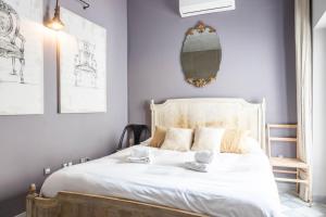 a bedroom with a white bed with a mirror on the wall at Blue Home by Cadiz Time in Cádiz