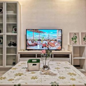 a living room with a tv and a table with flowers at R&F Mall,Country Style Seaview 2 bedrooms in Johor Bahru