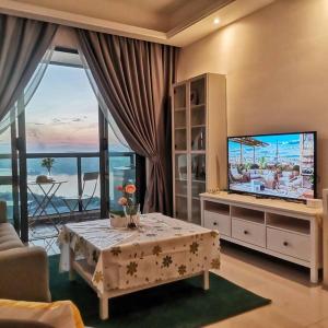a living room with a tv and a table and a couch at R&F Mall,Country Style Seaview 2 bedrooms in Johor Bahru