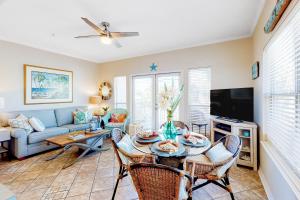 a living room with a table and chairs and a couch at Caribbean Dunes #226 in Destin