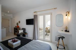 a bedroom with a bed and a sliding glass door at Naxos Earth Suites in Mikri Vigla