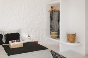 a bedroom with a bed and a white wall at Naxos Earth Suites in Mikri Vigla