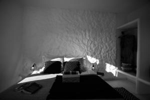 a black and white bedroom with a bed with pillows at Naxos Earth Suites in Mikri Vigla