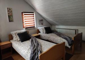 1 dormitorio con 2 camas y ventana en House Katja, en Jezerce