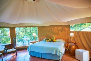 a bedroom with a bed and a balcony at Manoas in Uvita