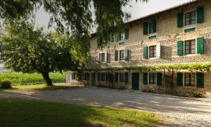 a large brick building with a tree in front of it at La di Morson Agriturismo in Camino al Tagliamento