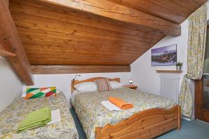 um quarto com 2 camas e um tecto de madeira em Mansarda alla Pineta em Giustino