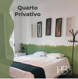 a bedroom with a green and white bed with pictures on the wall at HBB Hostel - Vila Madalena in Sao Paulo