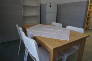 a wooden table with white chairs and a white refrigerator at Bett3de in Erding