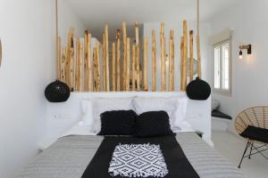 a bedroom with a bed with black and white pillows at Naxos Earth Suites in Mikri Vigla