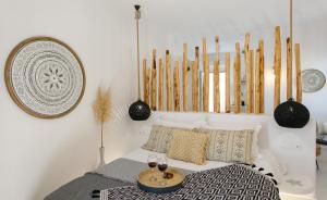 a bedroom with a bed with two glasses of wine at Naxos Earth Suites in Mikri Vigla