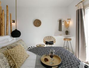 a bedroom with a bed with a tray with wine glasses on it at Naxos Earth Suites in Mikri Vigla