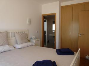 a bedroom with a bed with two blue towels on it at Rainha Juliana in Fuzeta