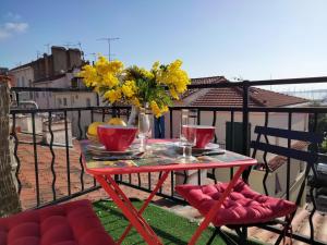 a red table with a vase of flowers on a balcony at Studio charmant avec vue sur la mer a Cannes 20 m&sup2; terrasse in Cannes