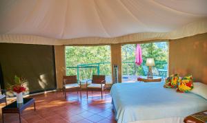 a bedroom with a large bed and a balcony at Manoas in Uvita