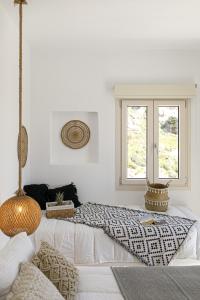 a white room with a bed and a window at Naxos Earth Suites in Mikri Vigla
