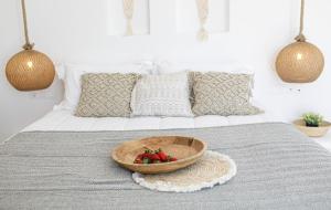 a bowl of strawberries sitting on top of a bed at Naxos Earth Suites in Mikri Vigla