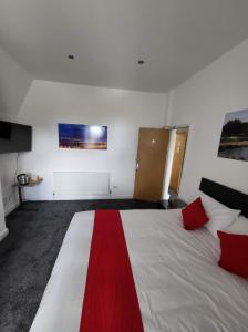 a room with a large bed with a red stripe on it at Park View in Hull