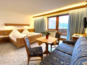 Pokój hotelowy z łóżkiem, kanapą i stołem w obiekcie Hotel Haus Seehang w Konstancji