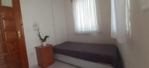 a small bedroom with a bed and a window at Mert Apart in Mugla