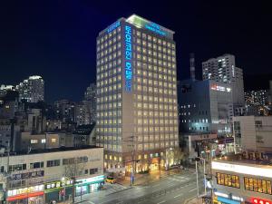 a tall building with blue lights on it in a city at Toyoko Inn Busan Seomyeon in Busan