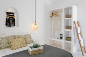 a white room with a couch and a shelf at Naxos Earth Suites in Mikri Vigla