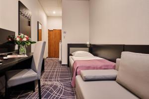 a hotel room with a bed and a couch at Sky Business Hotel in Legnica