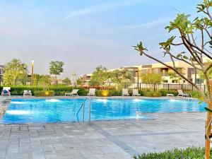a swimming pool with chairs in a courtyard at Modern Dubai Hills Luxury 4 BEDROOM VILLA in Dubai