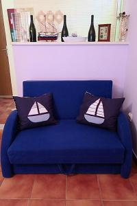 Un sofá azul con dos almohadas. en Apartments Vera, en Okuklje