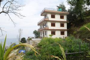a building on the side of a mountain at Patlekhet Eco Farmhouse in Dhulikhel