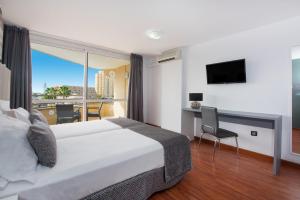 a hotel room with a large bed and a balcony at Olé Tropical Tenerife Adults Only in Playa de las Americas