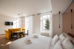a bedroom with a white bed and a table at Guesthouse diWINE in Merano