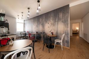une salle à manger avec des tables, des chaises et un mur dans l'établissement Guesthouse diWINE, à Merano