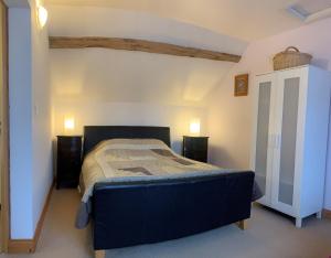 ein Schlafzimmer mit einem blauen Bett in einem Zimmer in der Unterkunft Le Glycine a Manoir Sainte Cecile in Juvigny-sous-Andaine