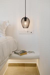 a bedroom with a bed and a table with a book at Naxos Earth Suites in Mikri Vigla