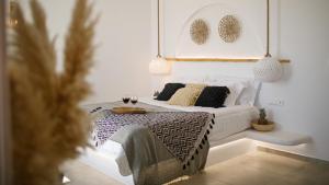 a bedroom with a bed with a table and two glasses of wine at Naxos Earth Suites in Mikri Vigla