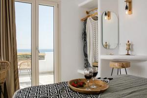 a room with a table with a plate of fruit and a glass of wine at Naxos Earth Suites in Mikri Vigla