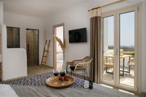 a living room with two glasses of wine on a table at Naxos Earth Suites in Mikri Vigla