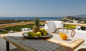 talerz owoców na stole ze szklanką soku pomarańczowego w obiekcie Naxos Earth Suites w mieście Mikri Vigla