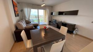 ein Wohnzimmer mit einem Tisch und Stühlen im Zimmer in der Unterkunft Precioso apartamento en complejo de al standing in Roses